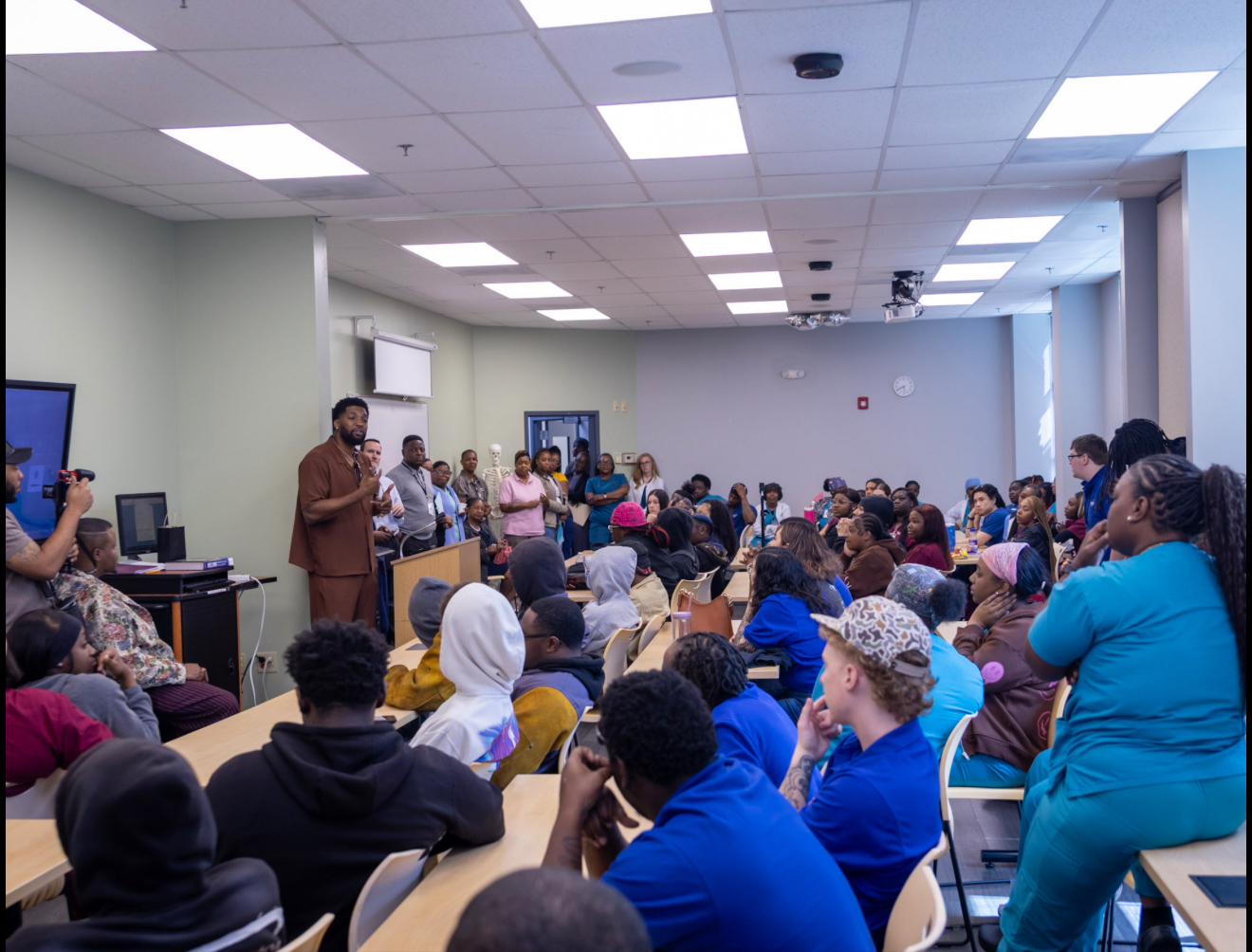 Dr. Joshua Randall teaching and speaking to a classroom audience